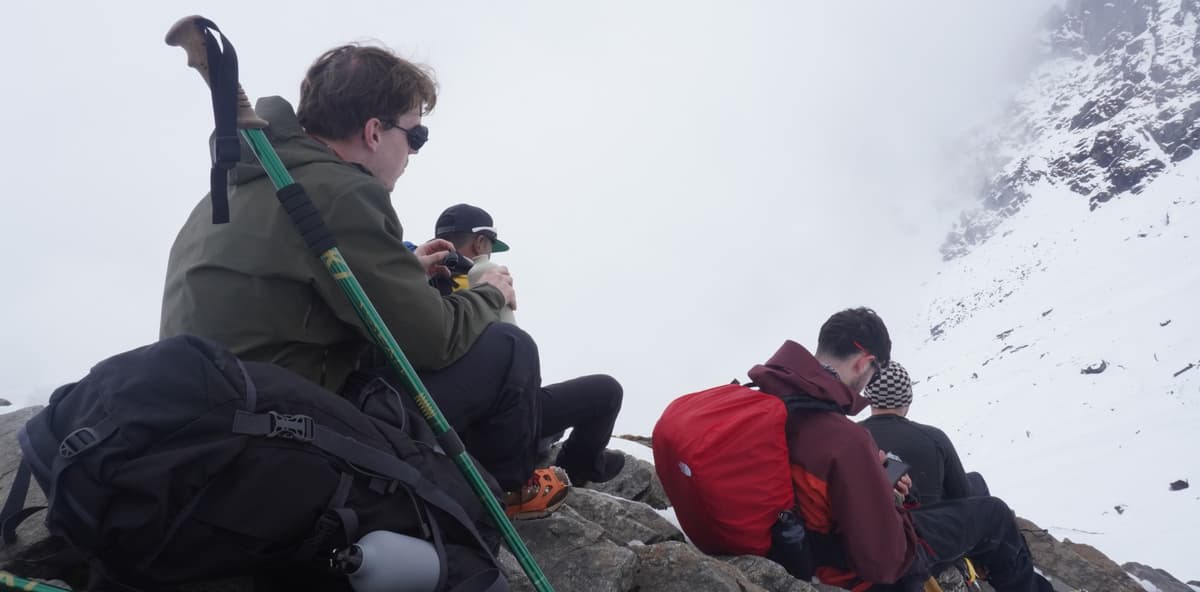 Rest During mera peak climbing This image shows hikers taking a break during a high-altitude trek during mera peak climbing.