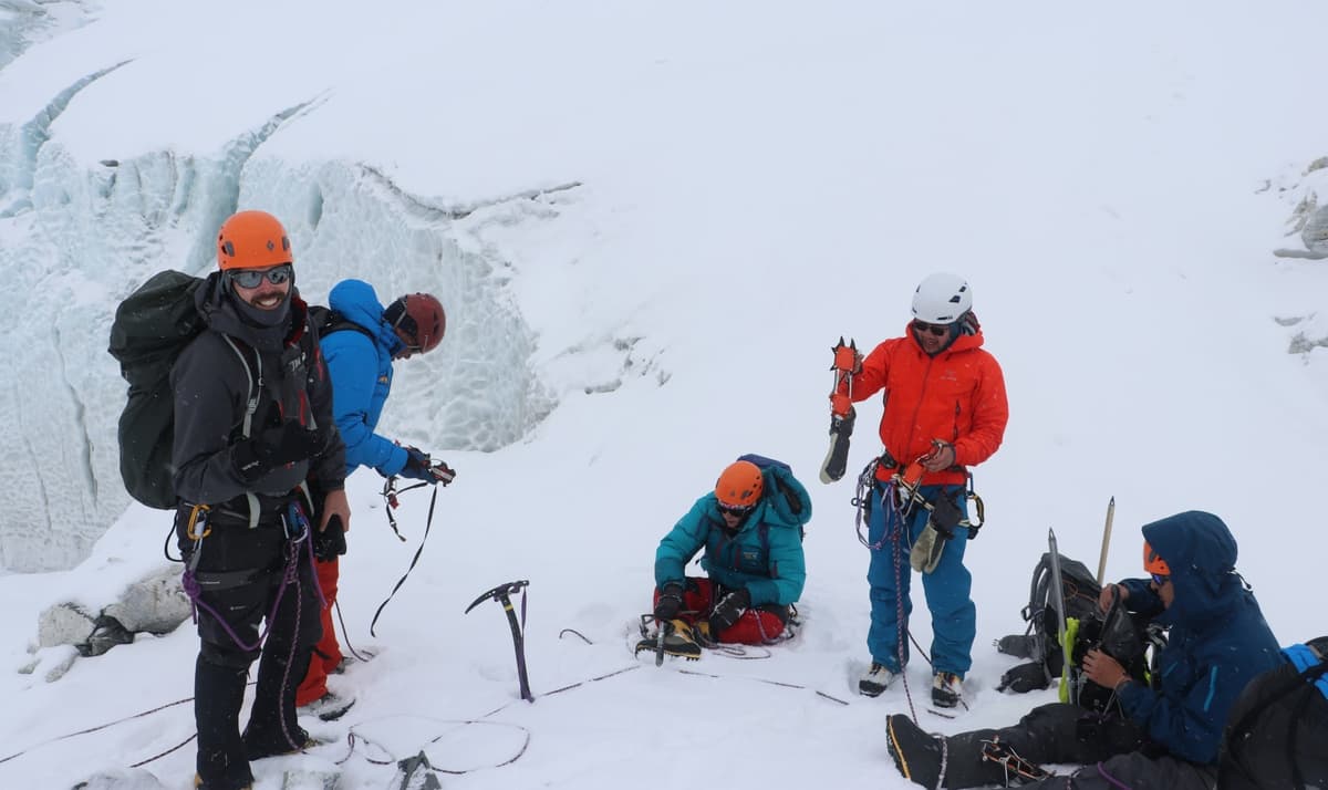 island-peak-summit-celebration-view Climbers on the summit ridge of Island Peak with Lhotse and Ama Dablam in view